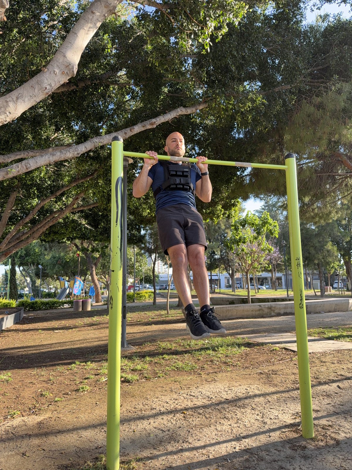 Ruben performing a weighted pull-up at an outdoor calisthenics park in Limassol.